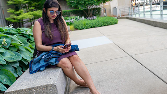 Women looking at her phone on a bench 