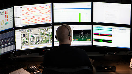 Person monitoring multiple computer screens