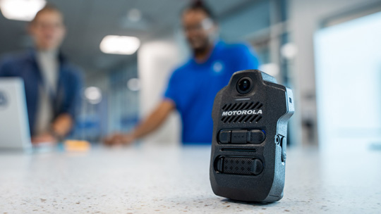 SVX video remote speaker mic in focus with people in background