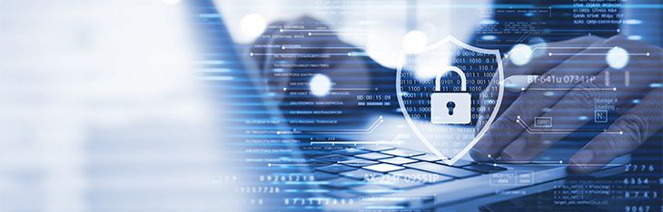 Person types on a laptop with graphics representing cybersecurity