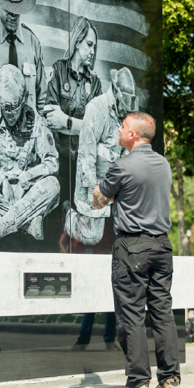 A person standing in front of a memorial.