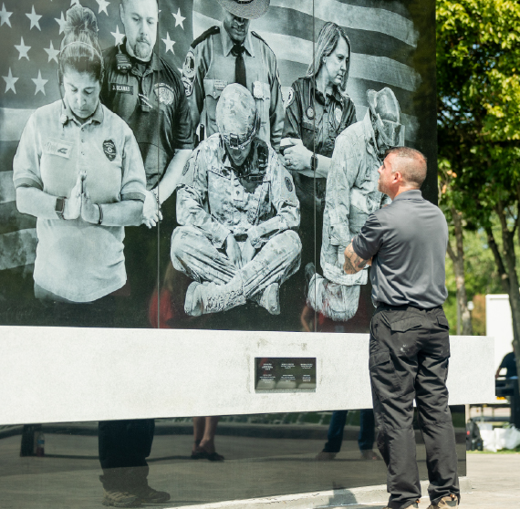 A person standing in front of a memorial.