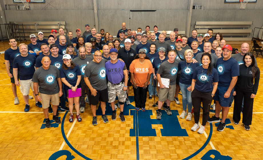 A group of people standing together on a basketball court.