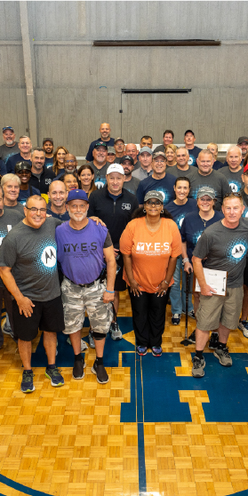 A group of people standing together on a basketball court.