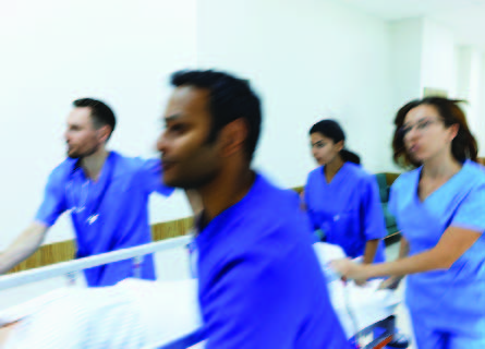 Nurses rushing through hospital with gurney