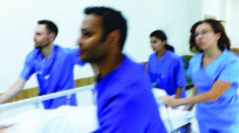 Nurses rushing through hospital with gurney