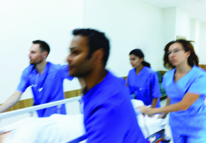 Nurses rushing through hospital with gurney