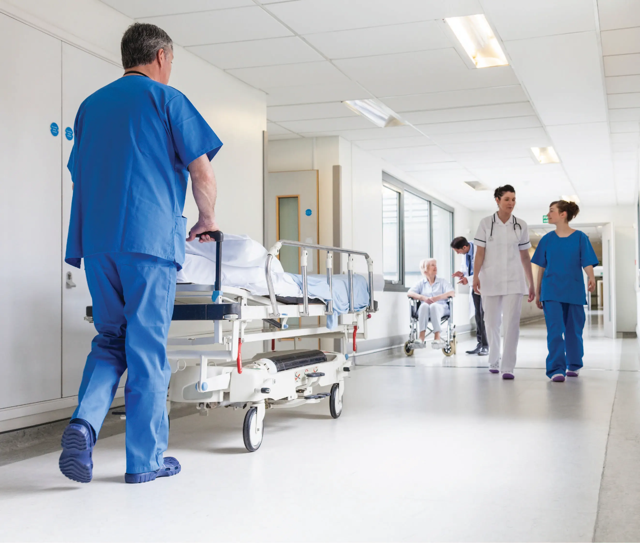 Hospital worker pushing patient in medical trolley