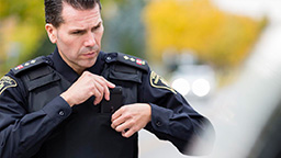 Police officer clicking on body camera