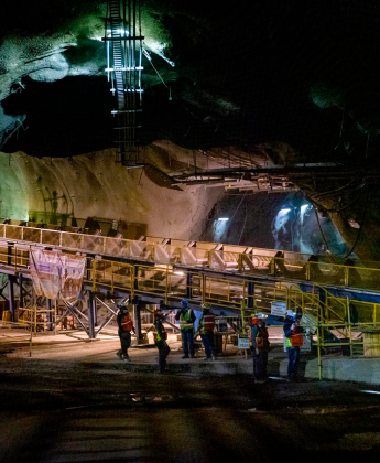 Man speaking into radio outside a manufacturing plant