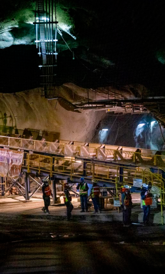 Man speaking into radio outside a manufacturing plant