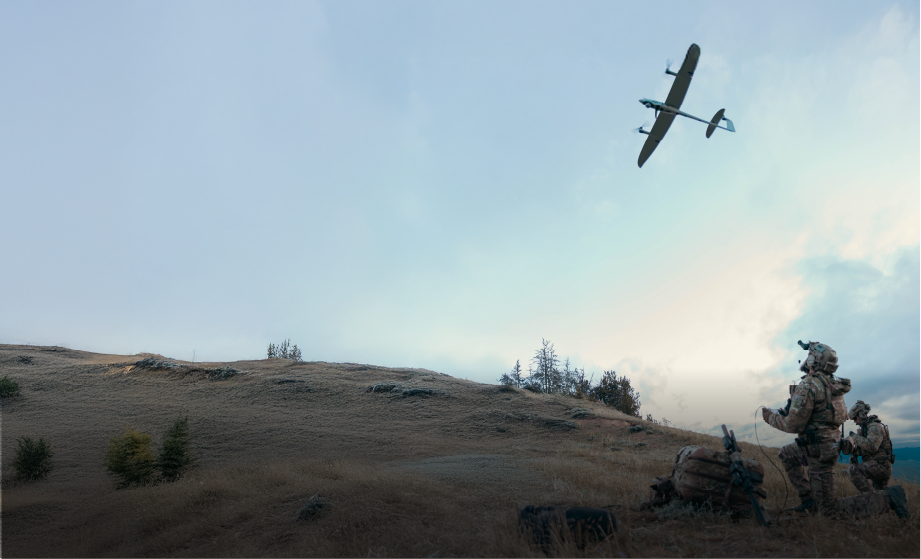Image of members of the military in camouflage outfit operating a drone in an open field