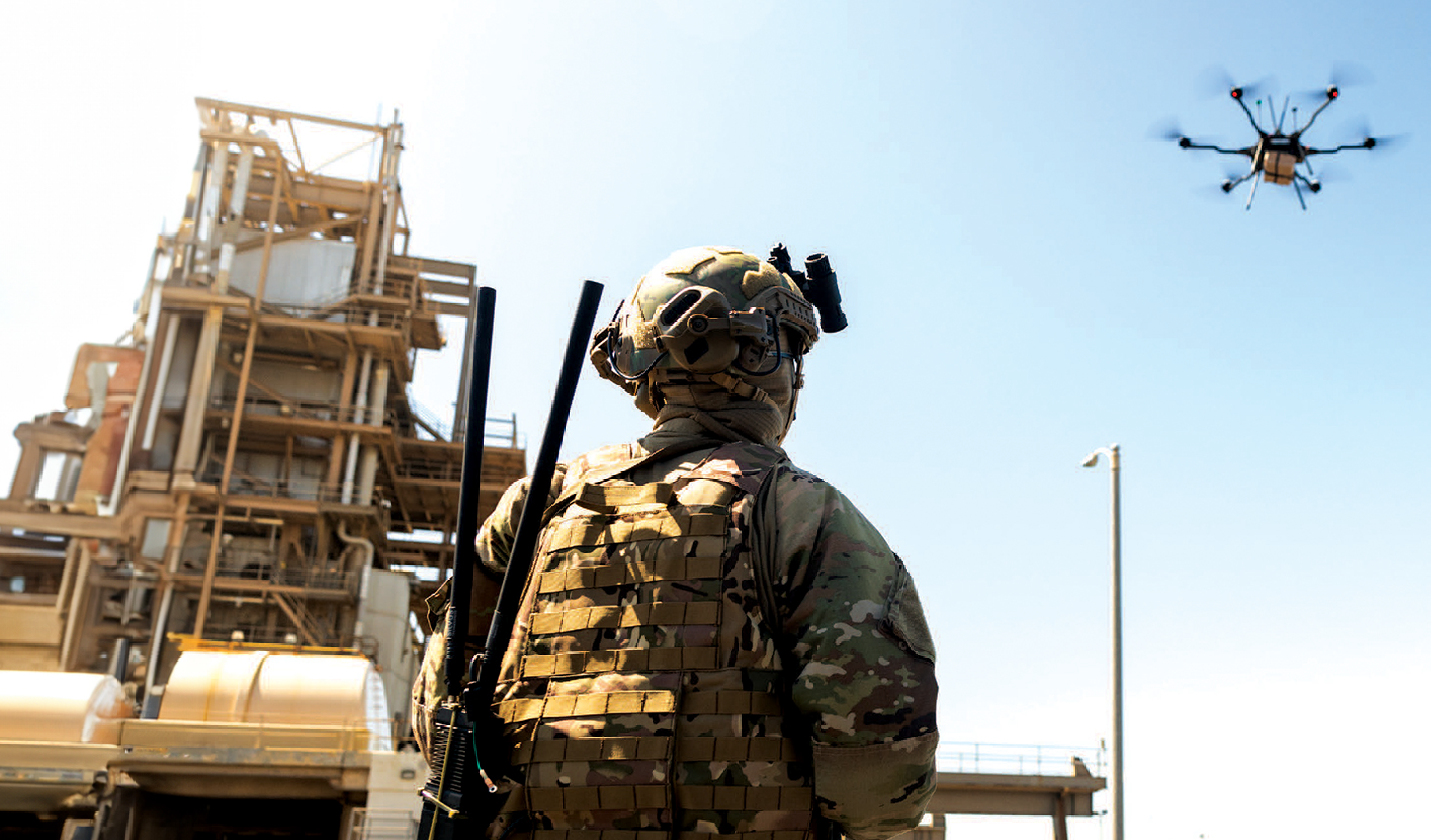 Image of military person in camouflage outfit operating a drone 