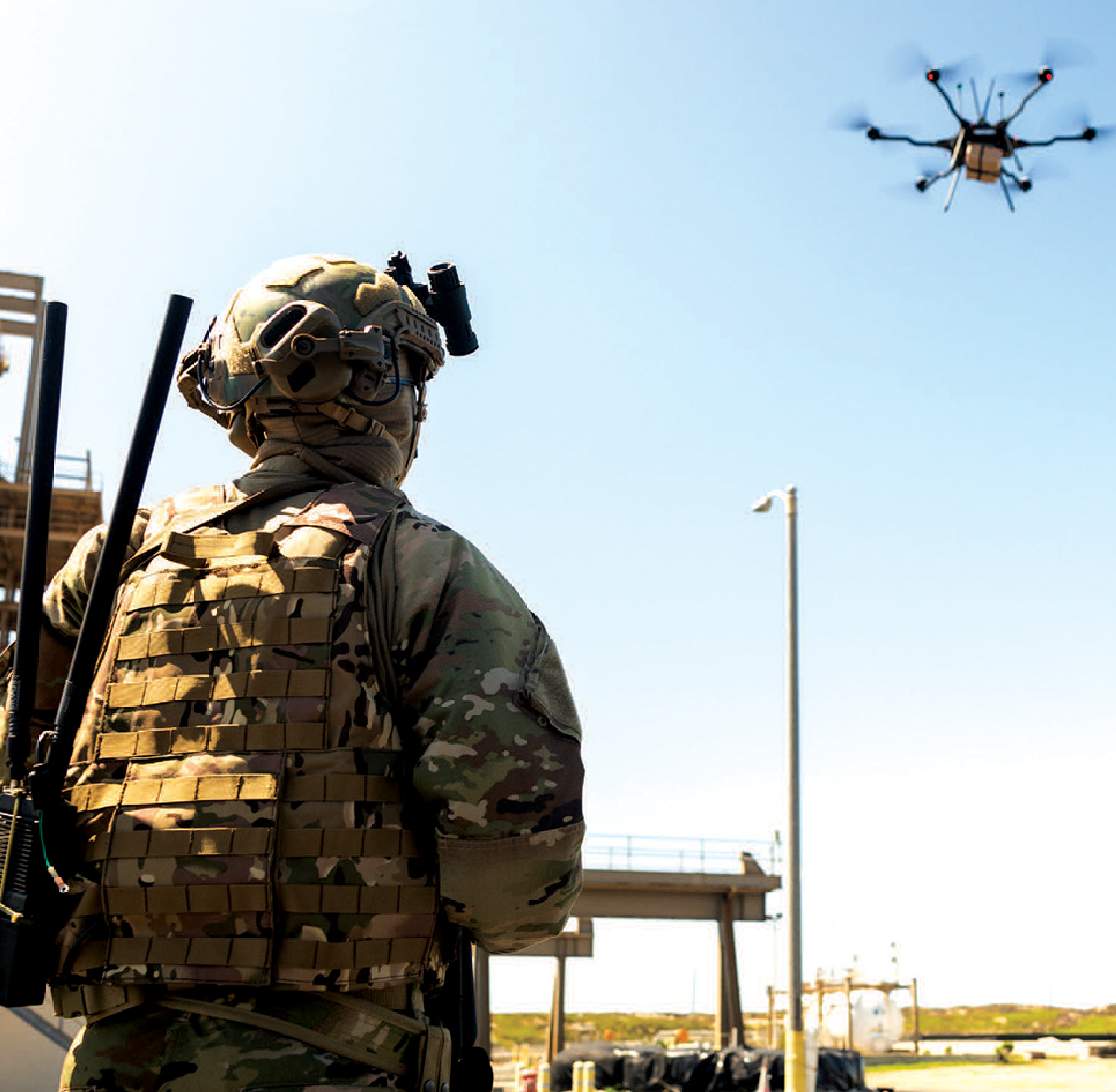 Image of military person in camouflage outfit operating a drone 