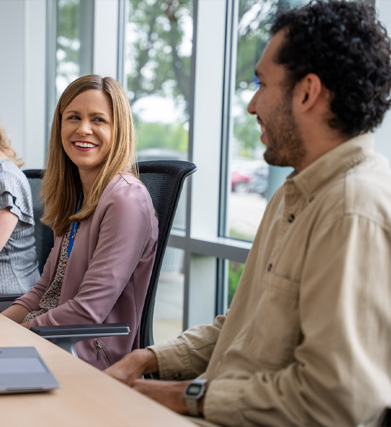 Image of smiling people at a conference table